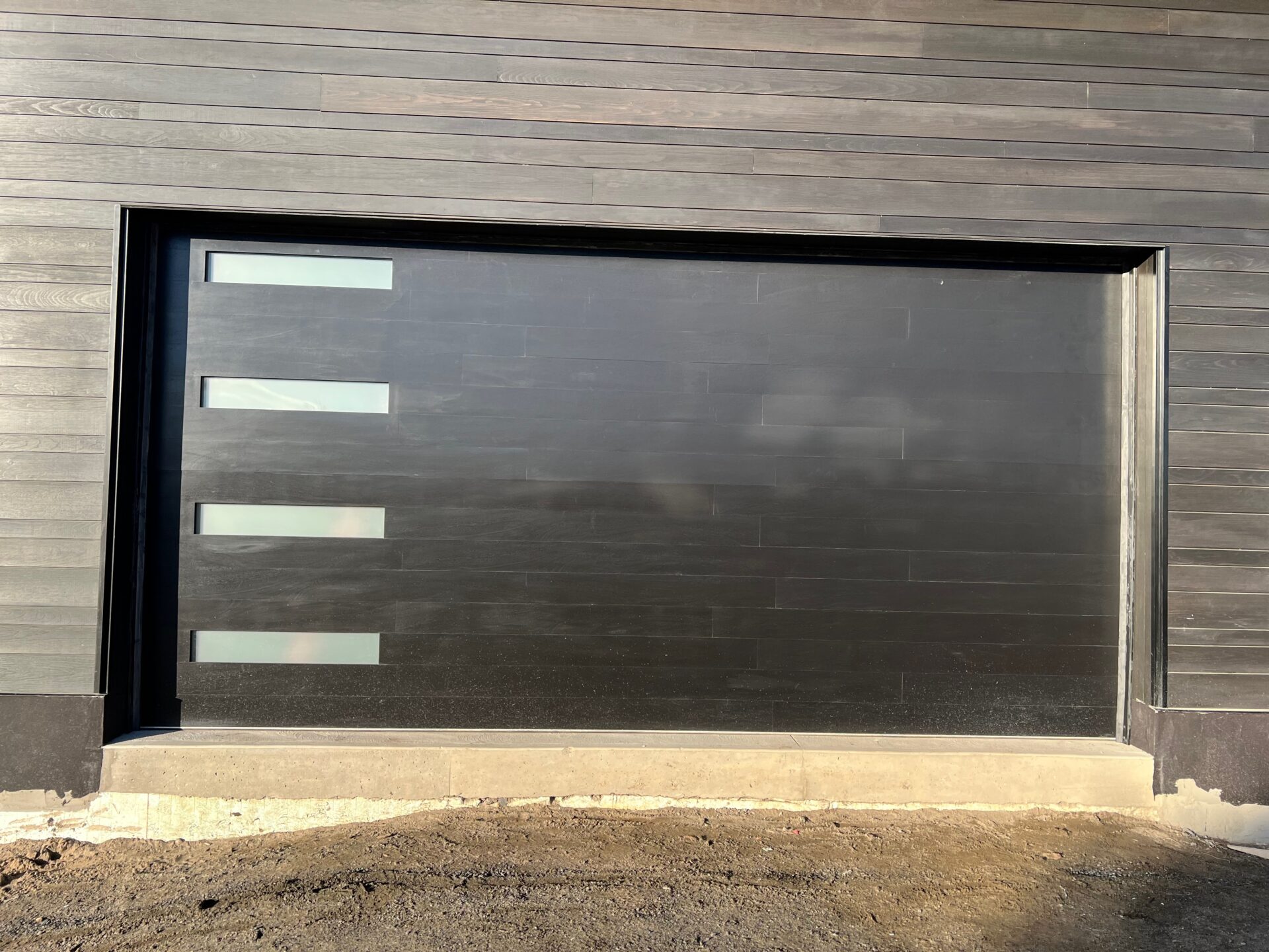 modern black garage door installed in Huntsville