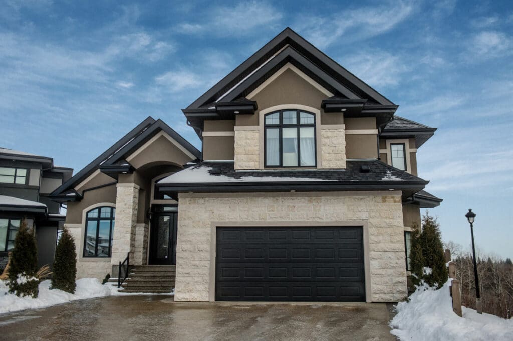 Black Steelcraft garage door on a house with snow around