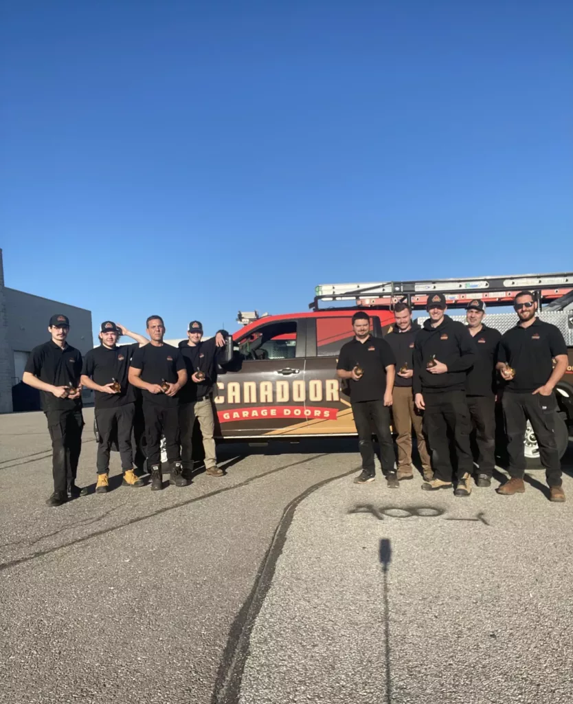 Garage door technicians standing for a group picture in front of a garage door service truck in Barrie