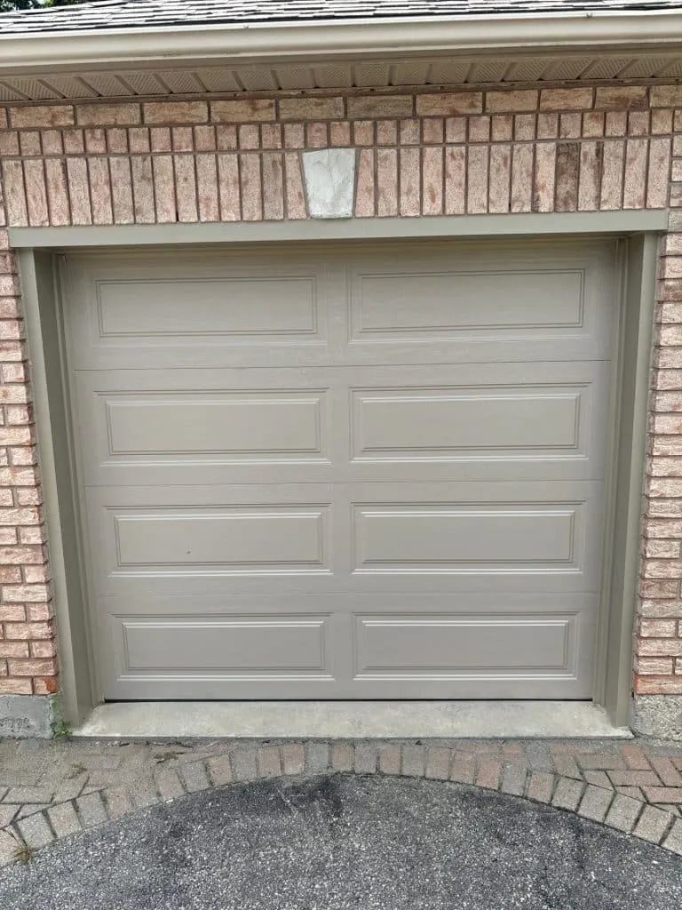 Garage door technician performing safety measures during a repair