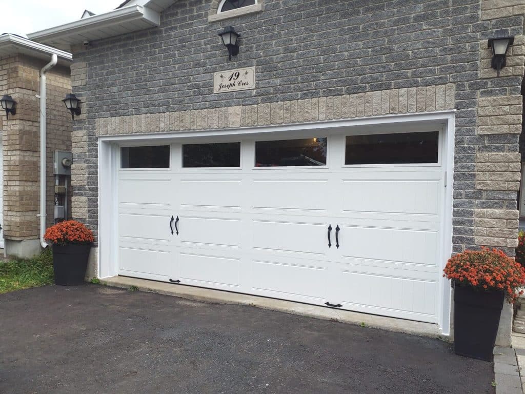 Residential garage door with decorative windows and wood-look finish