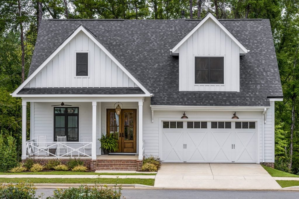 White carriage-style garage door with decorative windows on a modern farmhouse home