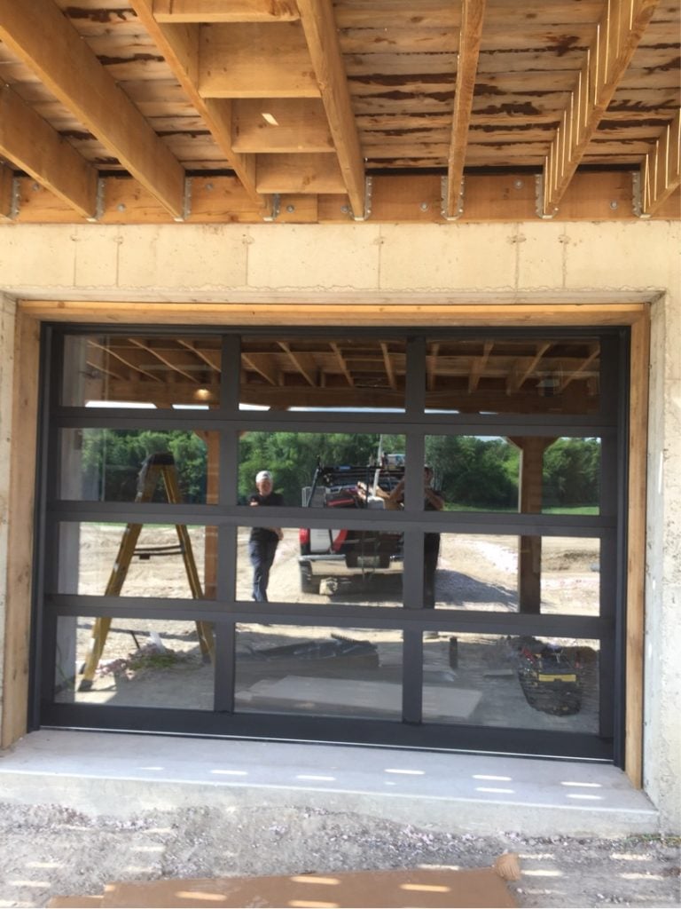 Black full-view glass garage door installed in a residential garage
